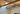 Black steel tie rods with turnbuckles bracing wood beams below a skylight