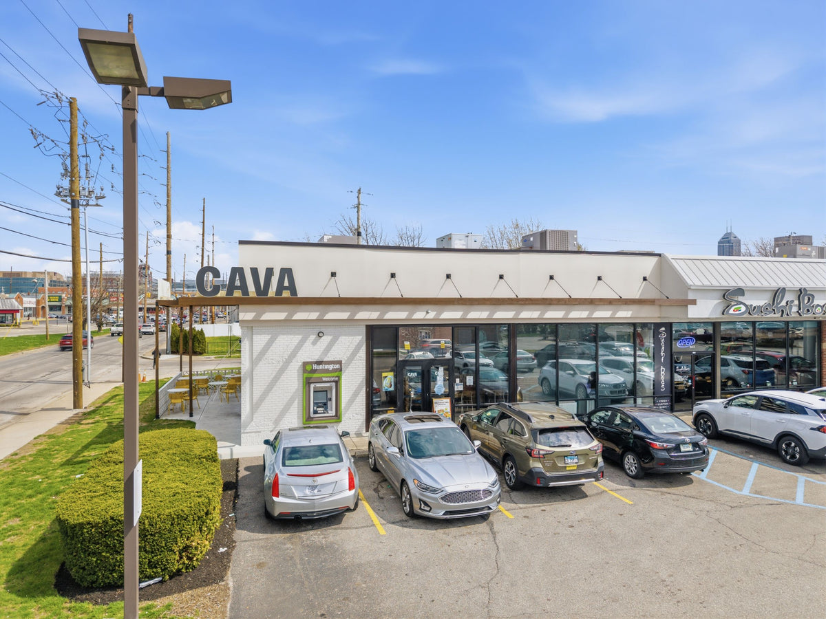 CAVA restaurant in Indianapolis, Indiana, with a timber awning hung on black steel tie rods across the storefront