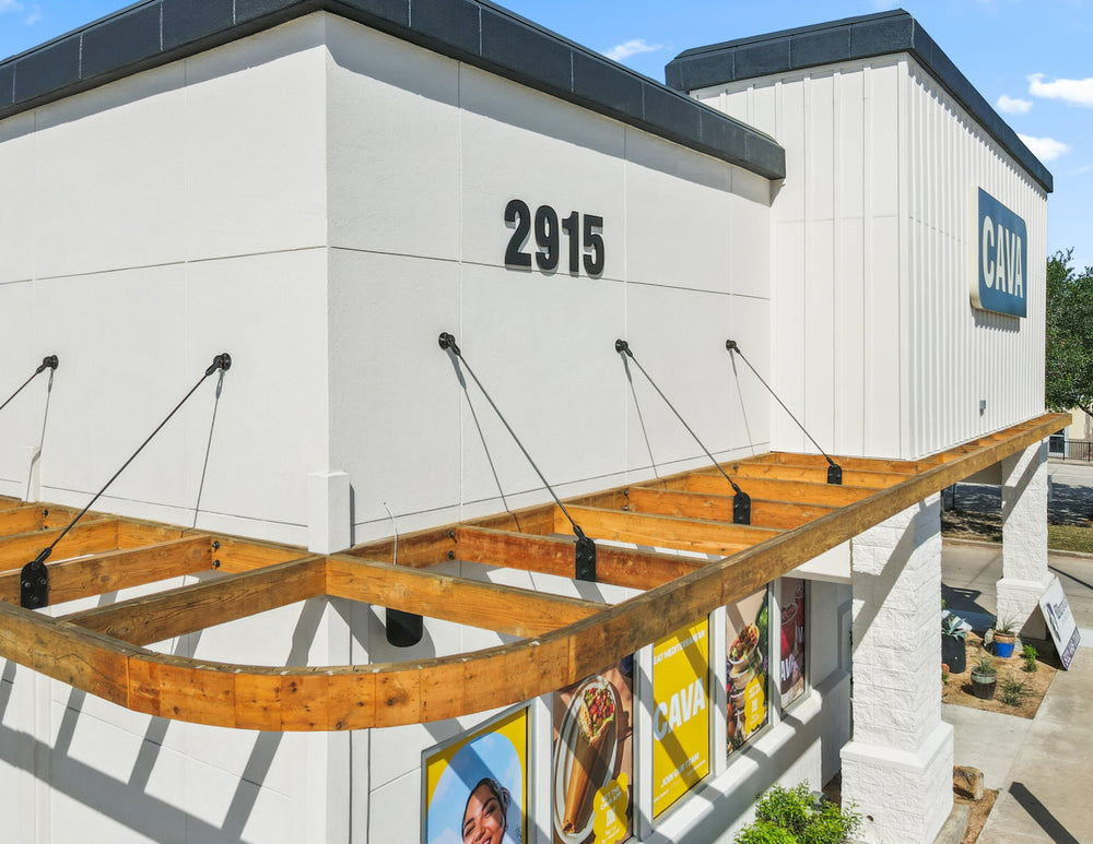 Black steel tie rods holding up a timber awning along a restaurant storefront