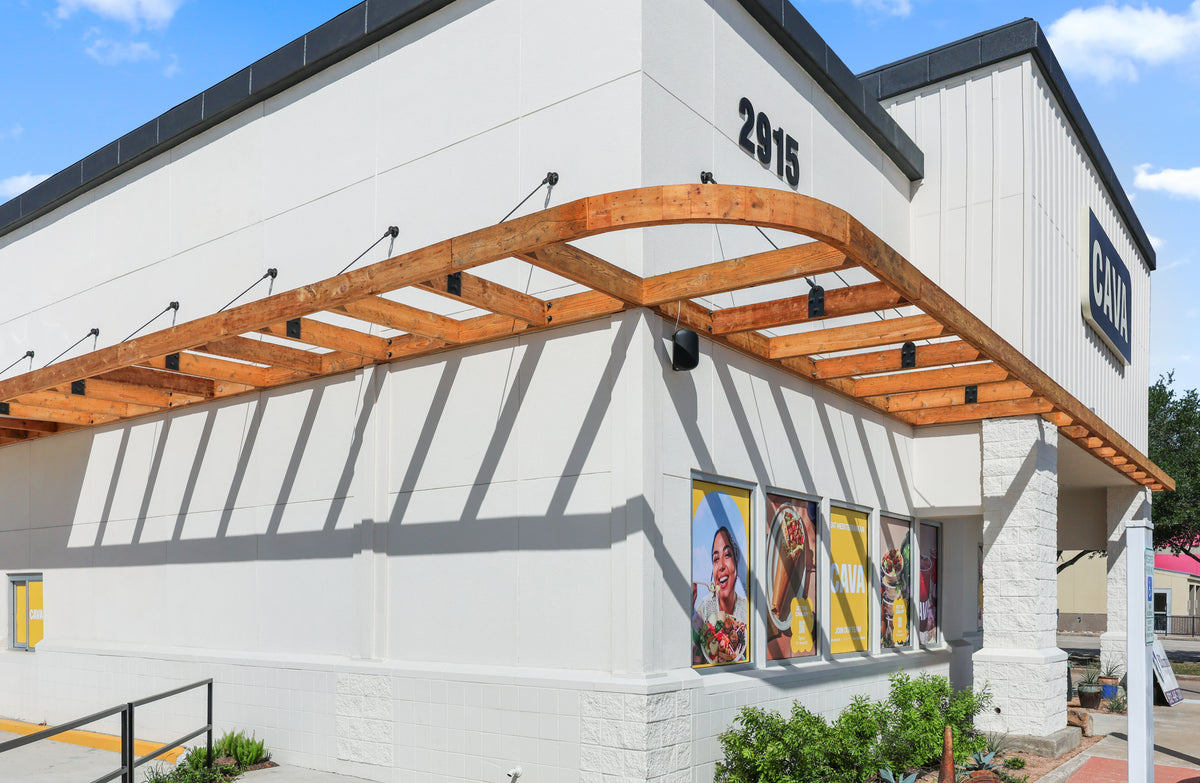 Curved corner of the timber awning at the League City CAVA, supported by black steel tie rods