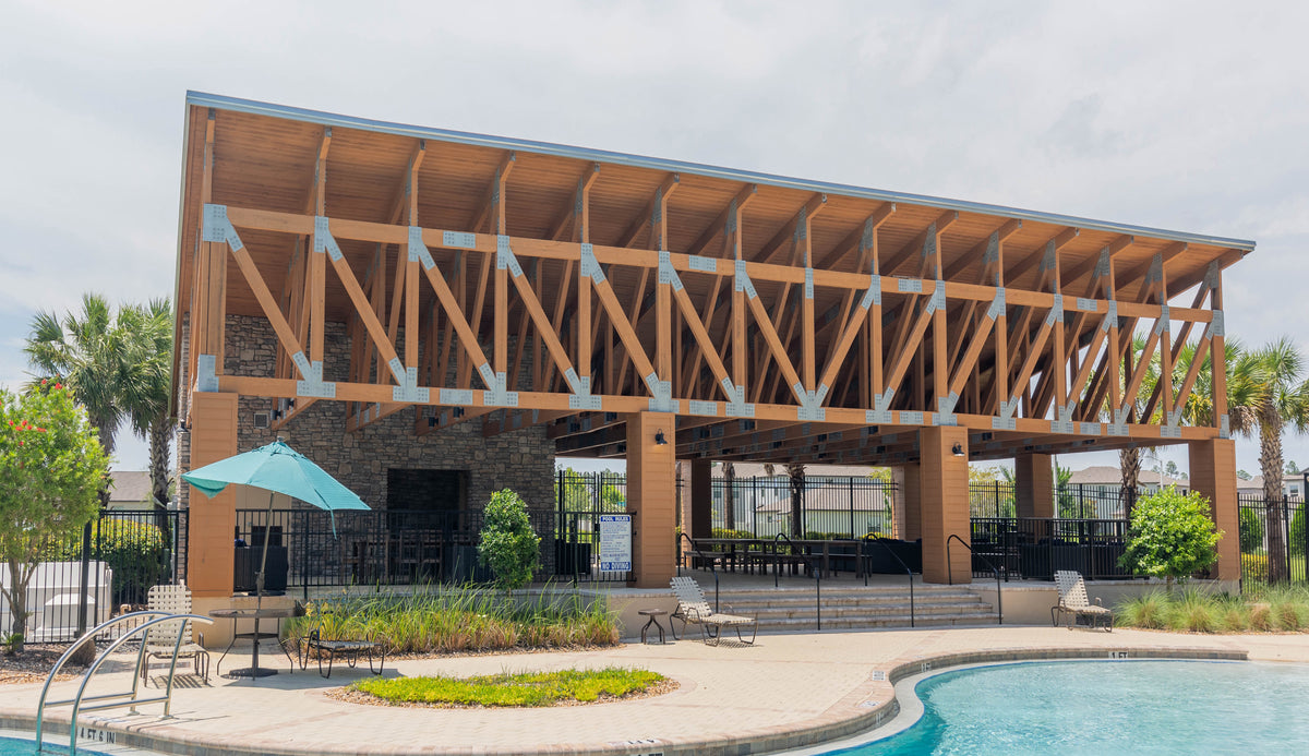 The finished timber pavilion from the same angle, beside the pool