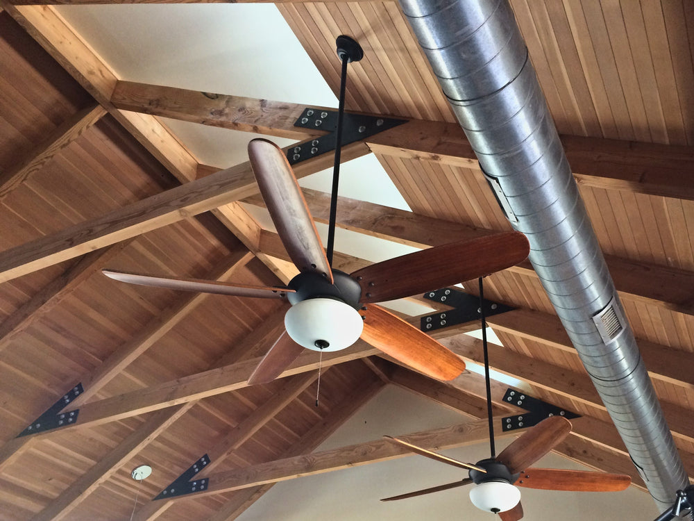Vaulted wood ceiling with exposed timber trusses joined by black steel plates